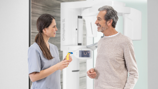 Assitant and patient speaking about the occlusal bite in front of a dental unit