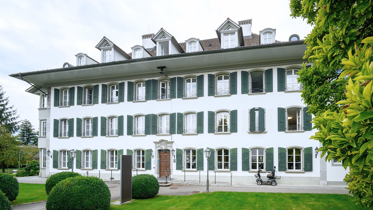 A historic building in green surroundings.
