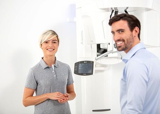 Assistant and patient smiling into the camera