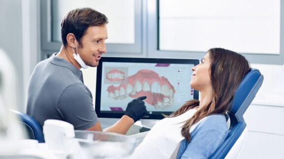 Tandarts die een patiënt adviseert, orthodontische behandeling met CEREC Ortho